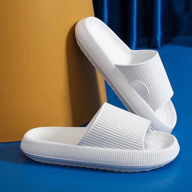 Weisse Hausschuhe am blaufarbigem Boden